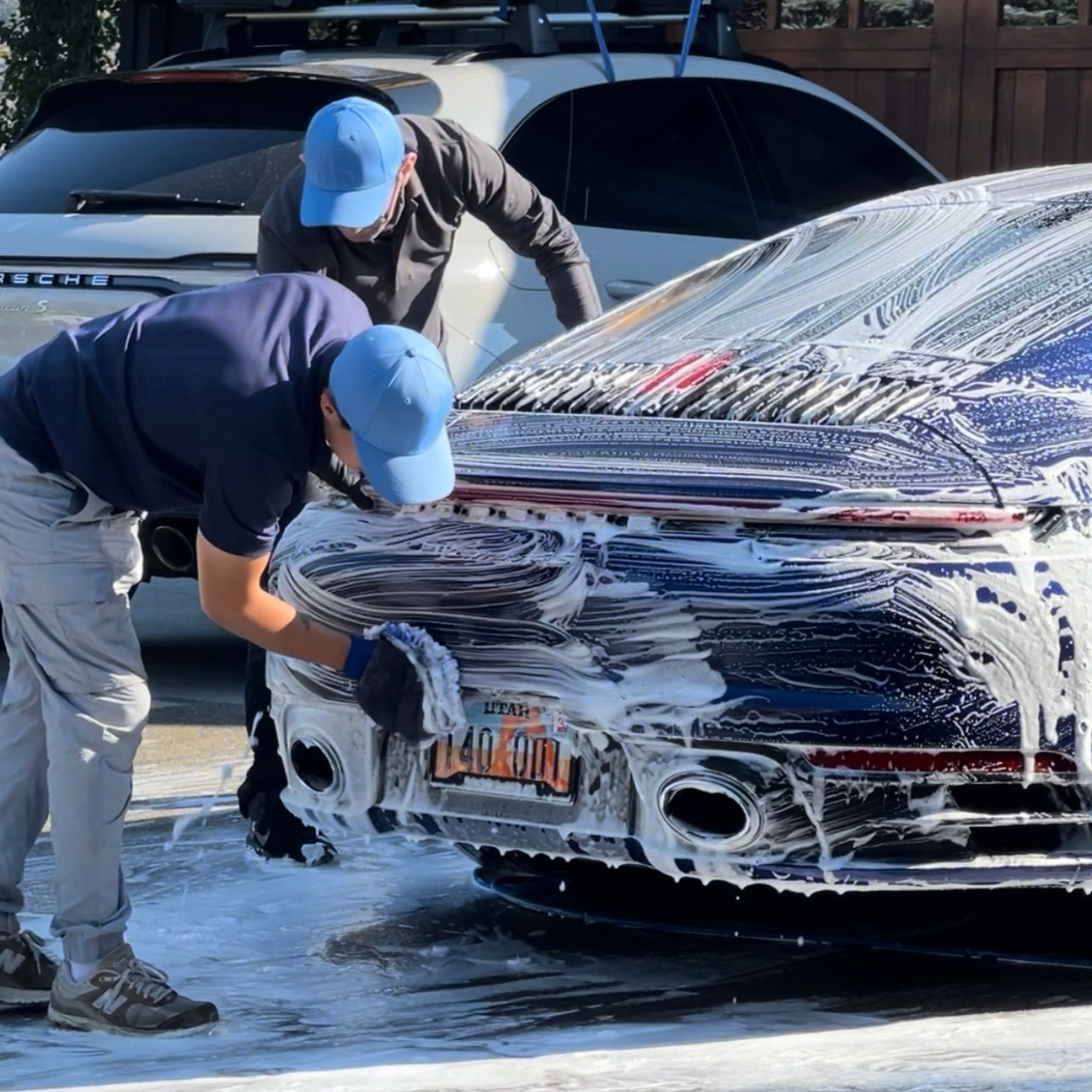 SparkClean technicians performing a mobile car detailing service with a foam bath in Park City, ensuring a spotless and professional finish.